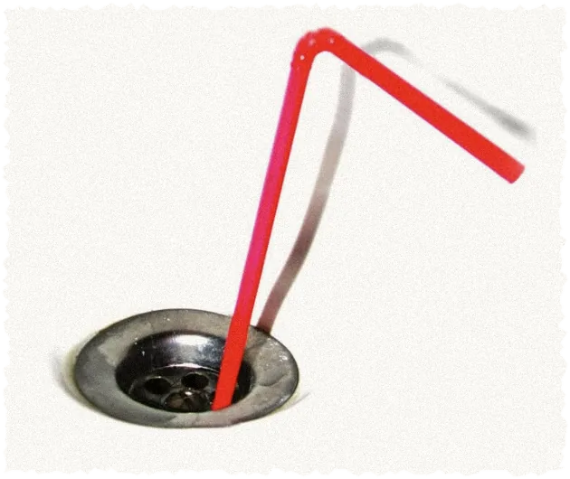 A red straw drinking from a sink drain